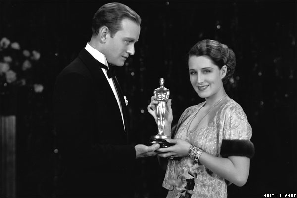 A atriz Norma Shearer recebe o prêmio em 1929 pelas mãos do ator Conrad Nigel por sua atuação no filme "A Divorciada"